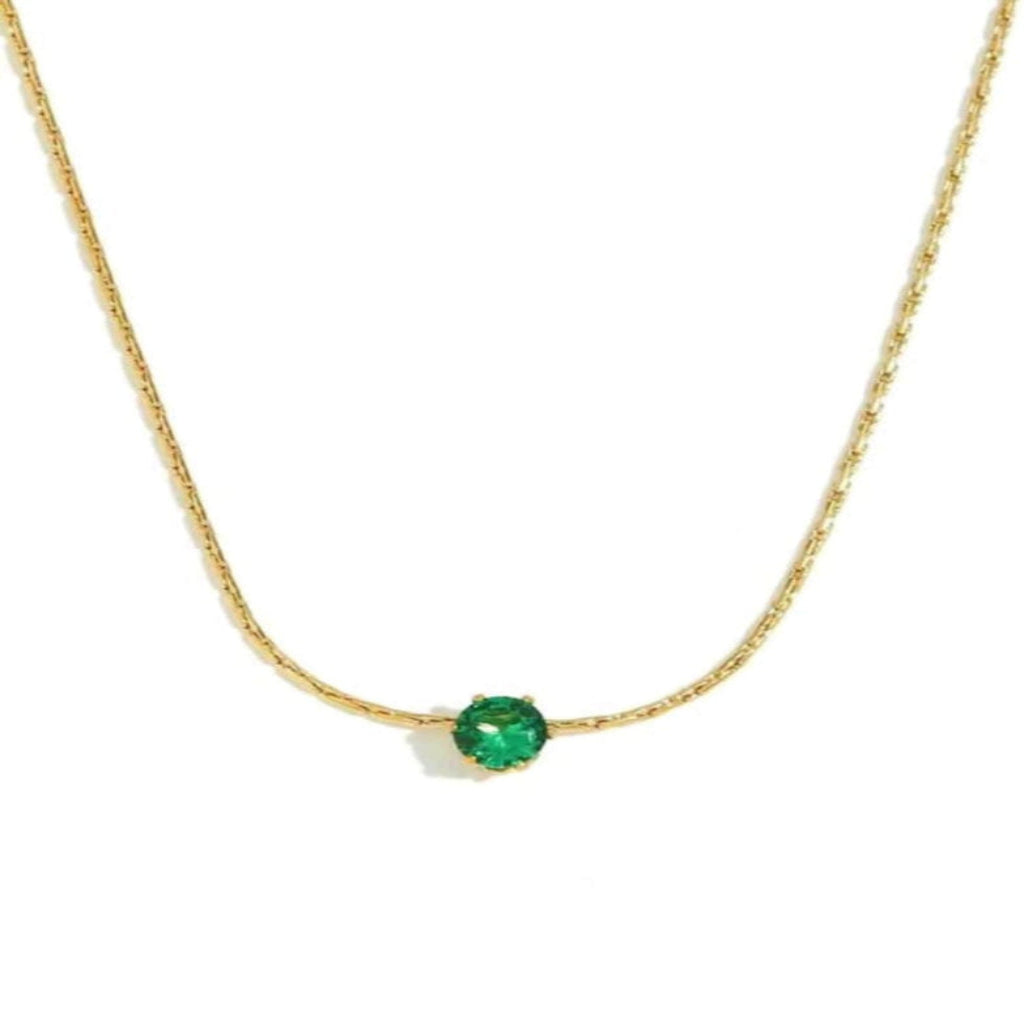 Gold necklace with a green gemstone on a white background